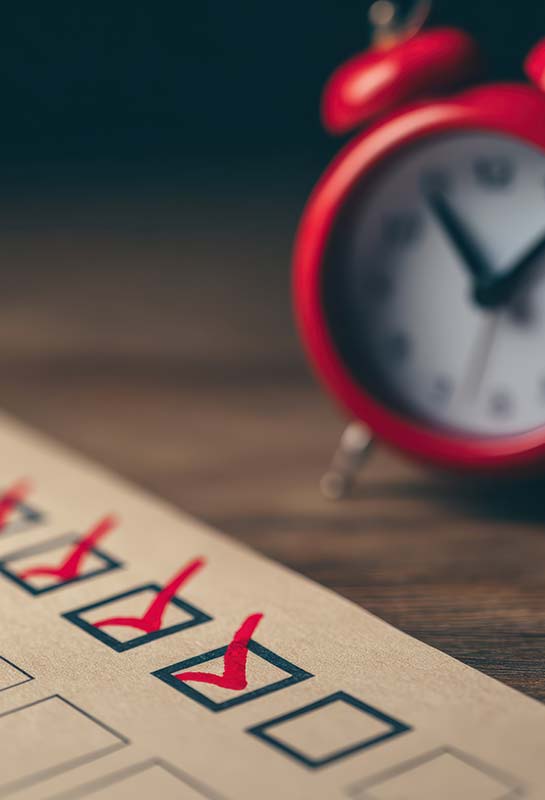 Transmission d’entreprise familiale — checklist de préparation Réveil rouge et checklist cochée, symbole de l’urgence de préparer la transmission d’entreprise familiale